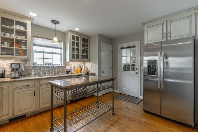 212 Cox Ln, Soddy Daisy, TN 37379 - kitchen with stainless steel fridge with ice dispenser, backsplash, light wood-style flooring, hanging light fixtures, and cream cabinetry