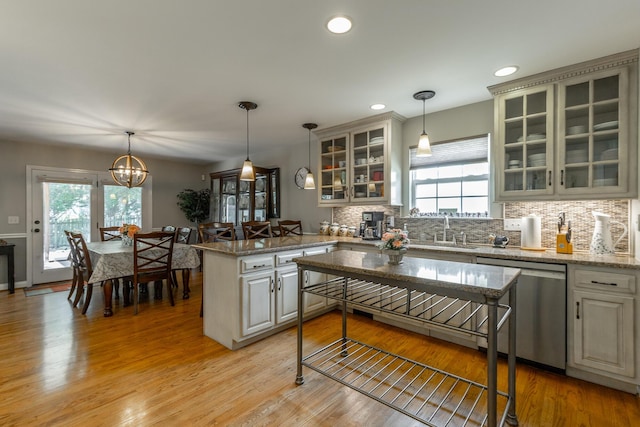 212 Cox Ln, Soddy Daisy, TN 37379 - kitchen featuring dishwasher, a peninsula, decorative backsplash, hanging light fixtures, and glass insert cabinets