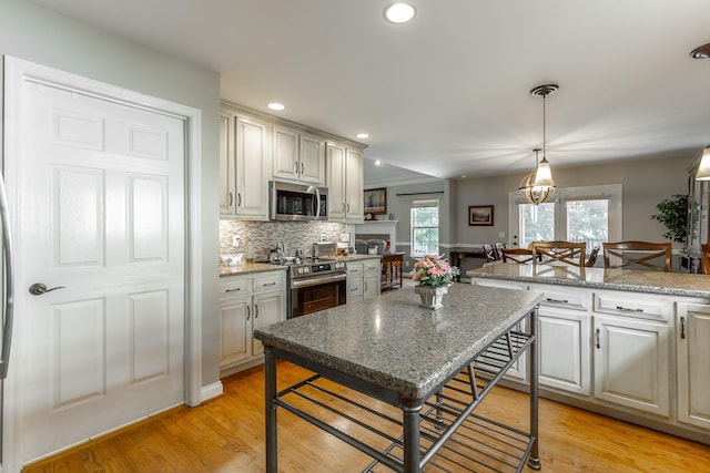 212 Cox Ln, Soddy Daisy, TN 37379 - kitchen with appliances with stainless steel finishes, tasteful backsplash, light wood-type flooring, pendant lighting, and recessed lighting