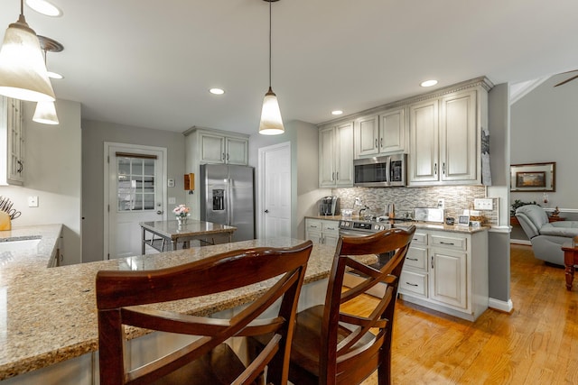 212 Cox Ln, Soddy Daisy, TN 37379 - kitchen featuring stainless steel appliances, backsplash, light wood finished floors, recessed lighting, and hanging light fixtures