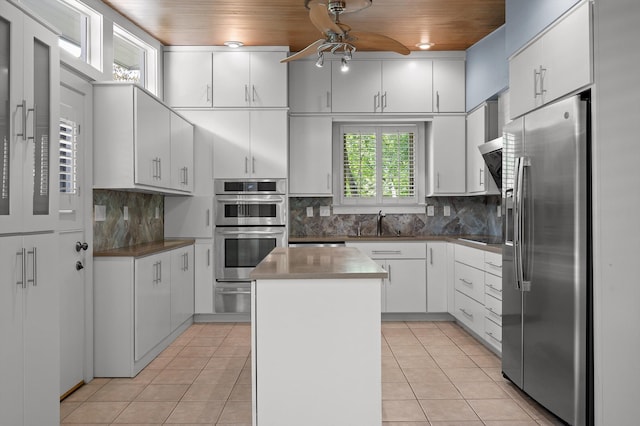2554 Crestwood Dr, Chattanooga, TN 37415 - kitchen featuring appliances with stainless steel finishes, a ceiling fan, a center island, light tile patterned flooring, and white cabinets