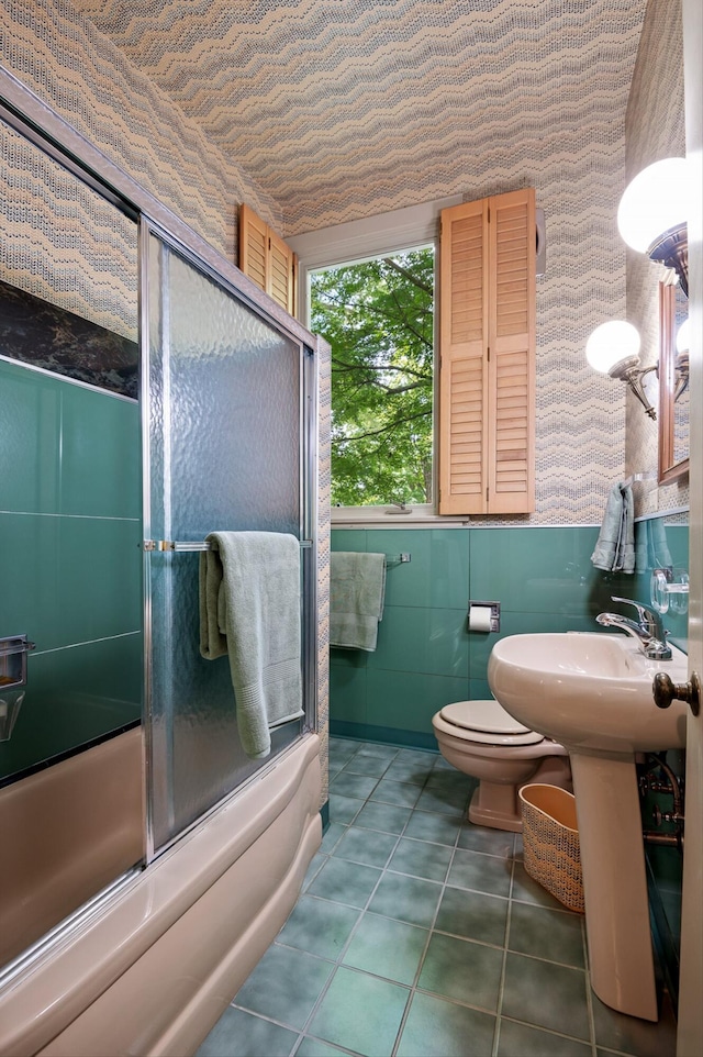 2554 Crestwood Dr, Chattanooga, TN 37415 - bathroom with wallpapered walls, combined bath / shower with glass door, tile walls, and wainscoting