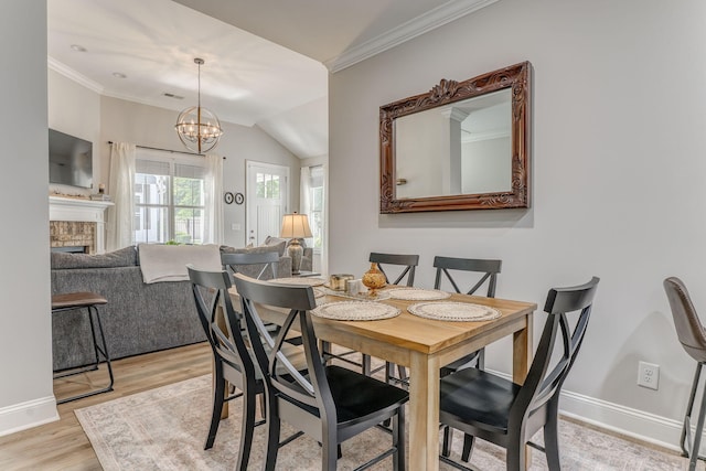 320 Kempton Ln Unit 2, Dalton, GA 30721 - dining space with crown molding, light wood-style floors, a chandelier, a fireplace, and vaulted ceiling