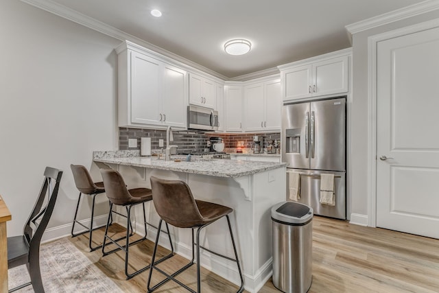 320 Kempton Ln Unit 2, Dalton, GA 30721 - kitchen featuring stainless steel appliances, a peninsula, white cabinetry, backsplash, and a breakfast bar