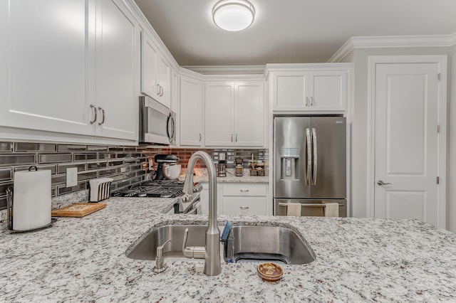 320 Kempton Ln Unit 2, Dalton, GA 30721 - kitchen with appliances with stainless steel finishes, white cabinets, tasteful backsplash, light stone countertops, and crown molding