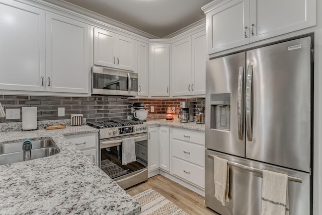 320 Kempton Ln Unit 2, Dalton, GA 30721 - kitchen with stainless steel appliances, white cabinets, tasteful backsplash, light wood-style floors, and light stone countertops