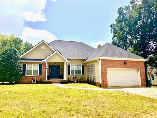 8041 Hamilton Mill Dr, Chattanooga, TN 37421 - view of front of house with an attached garage, brick siding, concrete driveway, a front yard, and a shingled roof