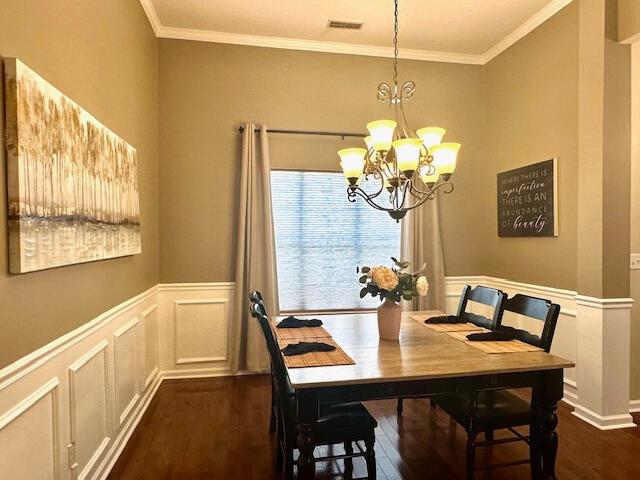 8041 Hamilton Mill Dr, Chattanooga, TN 37421 - dining area featuring a chandelier, dark wood-style floors, crown molding, wainscoting, and a decorative wall