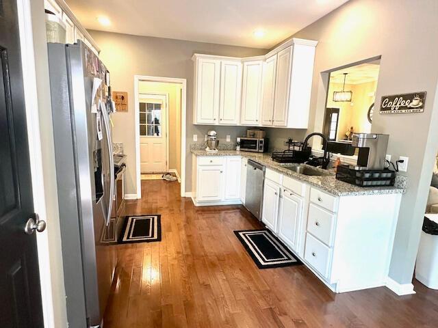 8041 Hamilton Mill Dr, Chattanooga, TN 37421 - kitchen with stainless steel appliances, dark wood-style flooring, white cabinets, light stone counters, and recessed lighting
