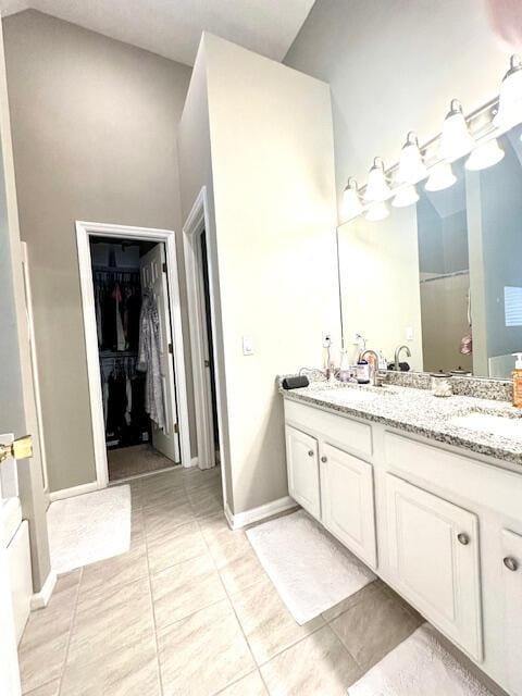 8041 Hamilton Mill Dr, Chattanooga, TN 37421 - bathroom with double vanity, a walk in closet, tile patterned floors, and high vaulted ceiling