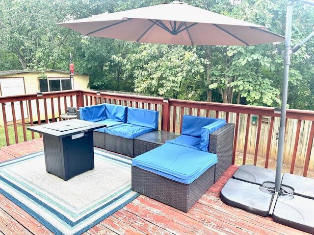 8041 Hamilton Mill Dr, Chattanooga, TN 37421 - deck with an outdoor living space with a fire pit, a storage unit, and view of scattered trees