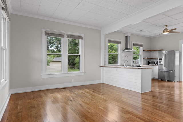 6863 Standifer Gap Rd, Chattanooga, TN 37421 - kitchen featuring stainless steel appliances, wall chimney range hood, backsplash, a peninsula, and light wood-style floors