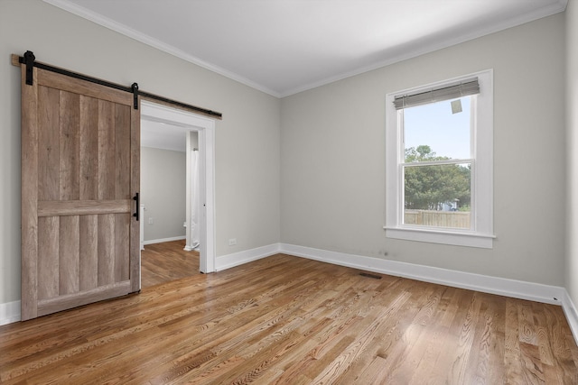 6863 Standifer Gap Rd, Chattanooga, TN 37421 - spare room with a barn door, ornamental molding, and light wood finished floors