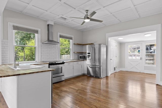 6863 Standifer Gap Rd, Chattanooga, TN 37421 - kitchen with appliances with stainless steel finishes, wood counters, wall chimney range hood, open shelves, and tasteful backsplash