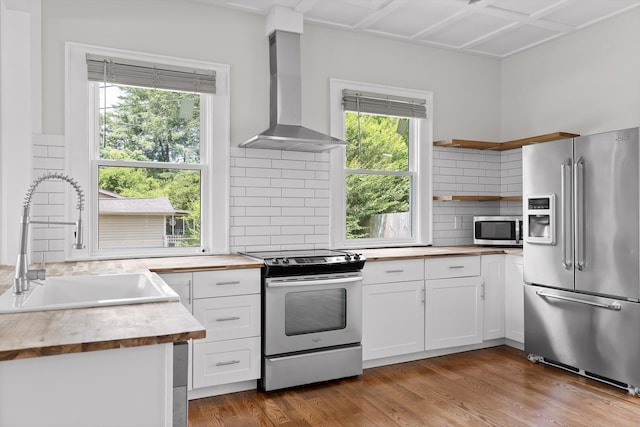 6863 Standifer Gap Rd, Chattanooga, TN 37421 - kitchen featuring appliances with stainless steel finishes, wall chimney range hood, tasteful backsplash, open shelves, and white cabinetry