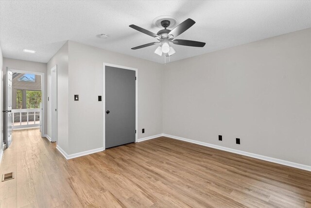 2219 Rocky Face Cir, Dalton, GA 30720 - spare room featuring light wood-style floors, ceiling fan, a textured ceiling, and a smoke detector
