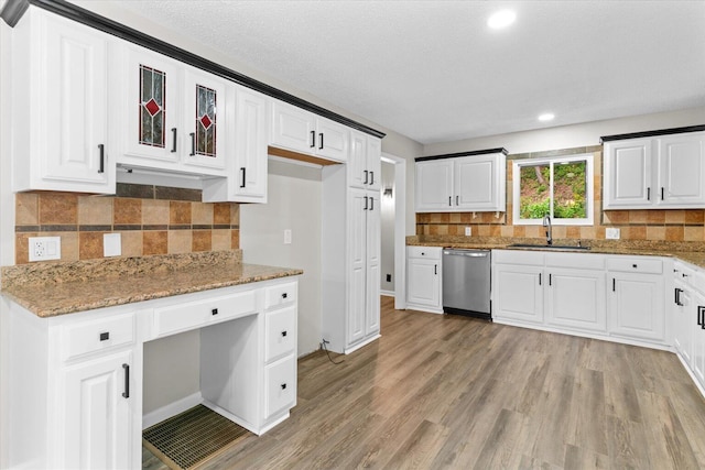 2219 Rocky Face Cir, Dalton, GA 30720 - kitchen with stainless steel dishwasher, light stone countertops, light wood-style flooring, tasteful backsplash, and white cabinetry