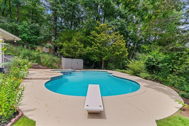 2219 Rocky Face Cir, Dalton, GA 30720 - view of swimming pool featuring a diving board, a pool with connected hot tub, a patio, and view of wooded area