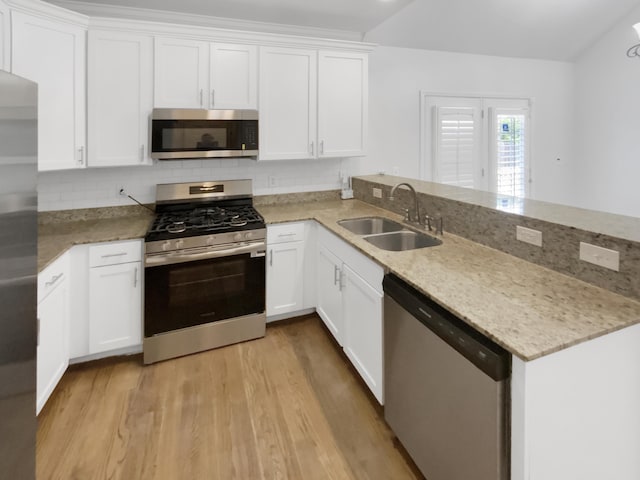 1783 Andover Pl, Chattanooga, TN 37421 - kitchen with appliances with stainless steel finishes, a peninsula, tasteful backsplash, light wood-type flooring, and white cabinetry