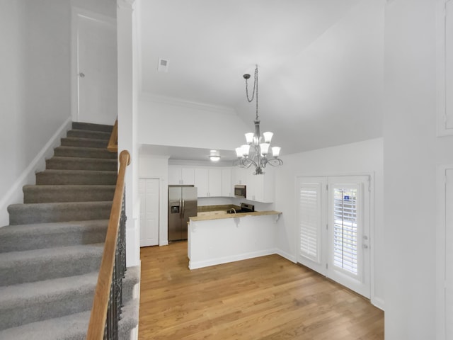 1783 Andover Pl, Chattanooga, TN 37421 - kitchen featuring stainless steel appliances, a peninsula, white cabinetry, a chandelier, and light wood-style flooring
