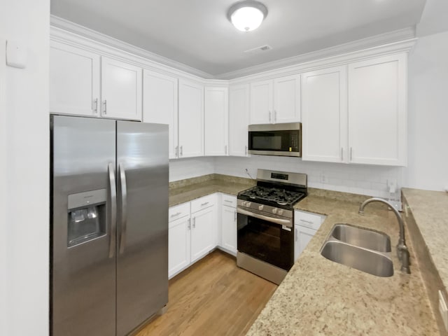 1783 Andover Pl, Chattanooga, TN 37421 - kitchen featuring stainless steel appliances, white cabinets, light wood finished floors, and tasteful backsplash