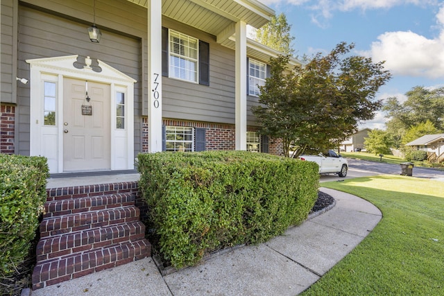 7700 Dune Ln, Hixson, TN 37343 - property entrance featuring brick siding, a yard, and a porch