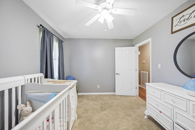 7700 Dune Ln, Hixson, TN 37343 - bedroom featuring light carpet, a nursery area, ceiling fan, and a textured ceiling