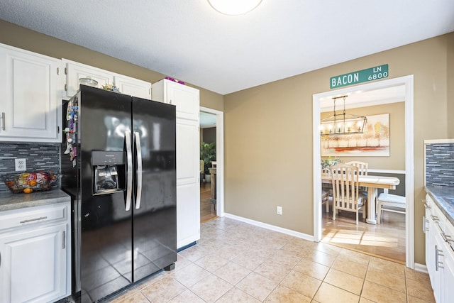 7700 Dune Ln, Hixson, TN 37343 - kitchen featuring refrigerator with ice dispenser, a chandelier, backsplash, white cabinets, and light tile patterned flooring
