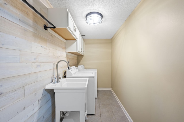 7700 Dune Ln, Hixson, TN 37343 - laundry area featuring washer and clothes dryer, cabinet space, a textured ceiling, wood walls, and light tile patterned floors