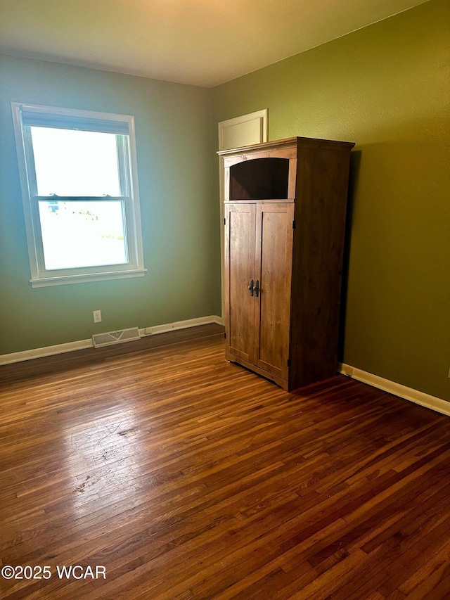 510 Rosewood Ave, Findlay, OH 45840 - unfurnished bedroom with dark wood-style flooring, baseboards, and visible vents