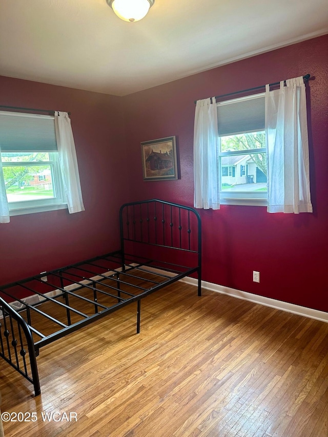510 Rosewood Ave, Findlay, OH 45840 - bedroom with baseboards, wood finished floors, and multiple windows