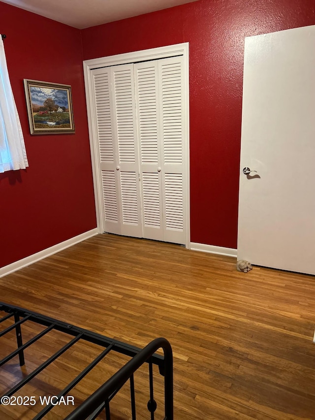 510 Rosewood Ave, Findlay, OH 45840 - unfurnished bedroom with baseboards, wood finished floors, and a closet