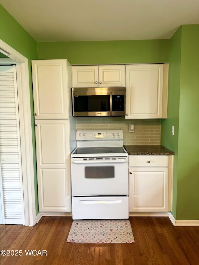 510 Rosewood Ave, Findlay, OH 45840 - kitchen with stainless steel microwave, dark wood-style floors, white cabinetry, and electric stove