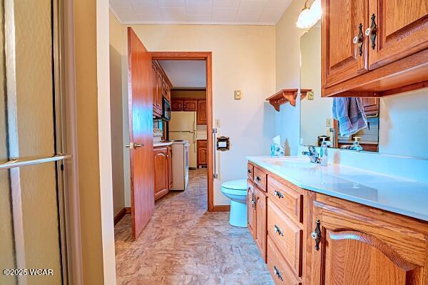 bathroom featuring vanity, toilet, and a shower with shower door