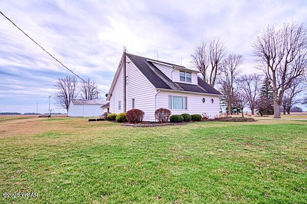 view of side of home with a yard