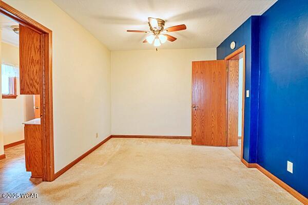 carpeted empty room featuring ceiling fan