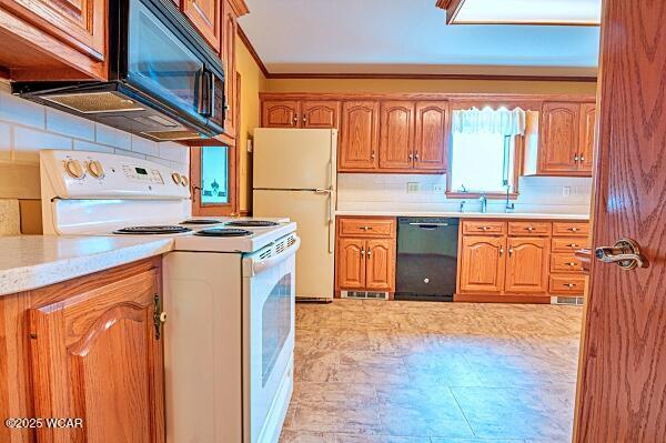 kitchen with tasteful backsplash, ornamental molding, light stone counters, and white appliances