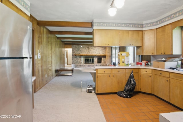 kitchen featuring brick floor, light countertops, and freestanding refrigerator