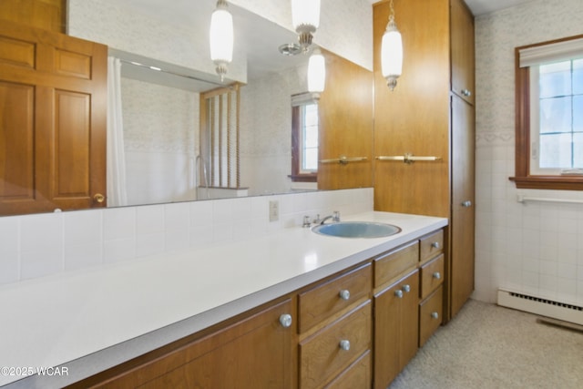 full bathroom featuring a baseboard heating unit, a healthy amount of sunlight, vanity, and wallpapered walls