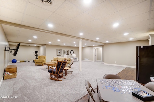 living room with a drop ceiling and carpet floors