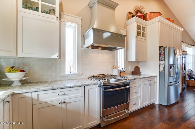 kitchen featuring white cabinetry, light stone countertops, stainless steel appliances, and custom range hood