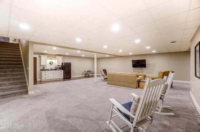 carpeted living room featuring a paneled ceiling