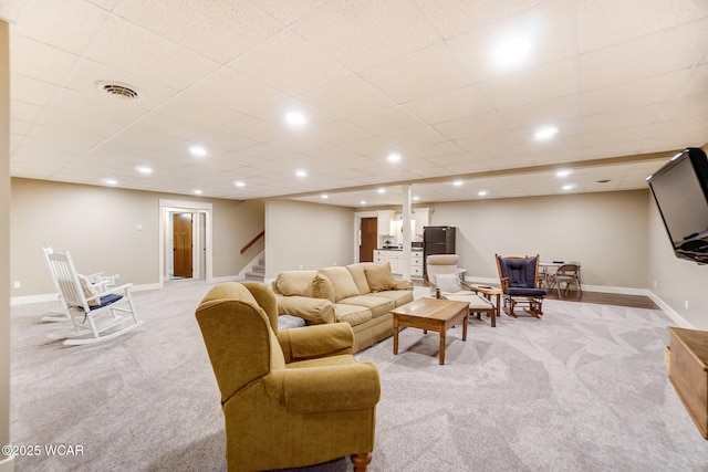 living room with light carpet and a drop ceiling