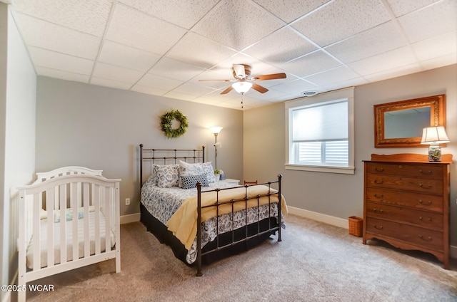 carpeted bedroom featuring a drop ceiling and ceiling fan