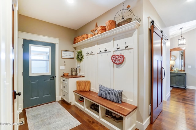 mudroom featuring a barn door and dark hardwood / wood-style flooring