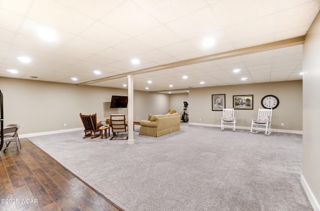 living room featuring a paneled ceiling and dark colored carpet