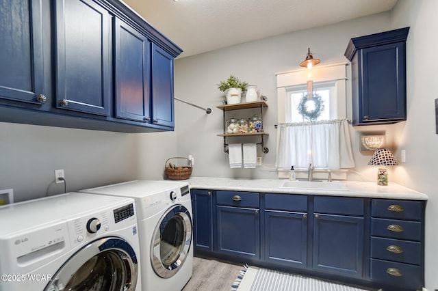 washroom with cabinets, washer and dryer, sink, and light wood-type flooring