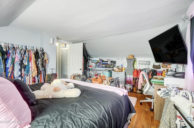 bedroom featuring vaulted ceiling and light wood-type flooring