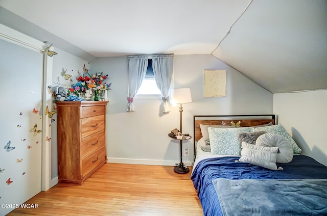 bedroom featuring lofted ceiling and light hardwood / wood-style floors