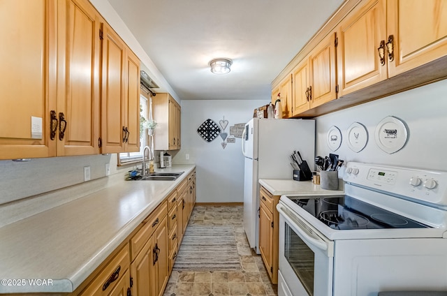 kitchen with light countertops, white appliances, a sink, and baseboards